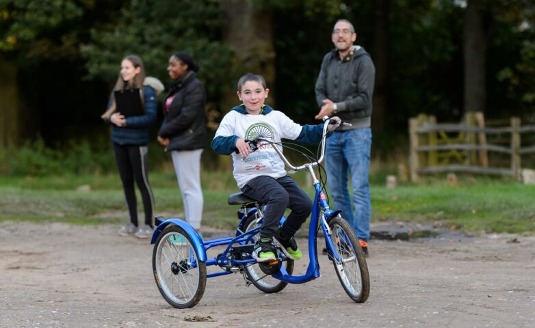 Boy using adaptive bicycle