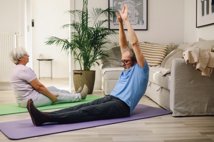 Older man and woman doing stretches.