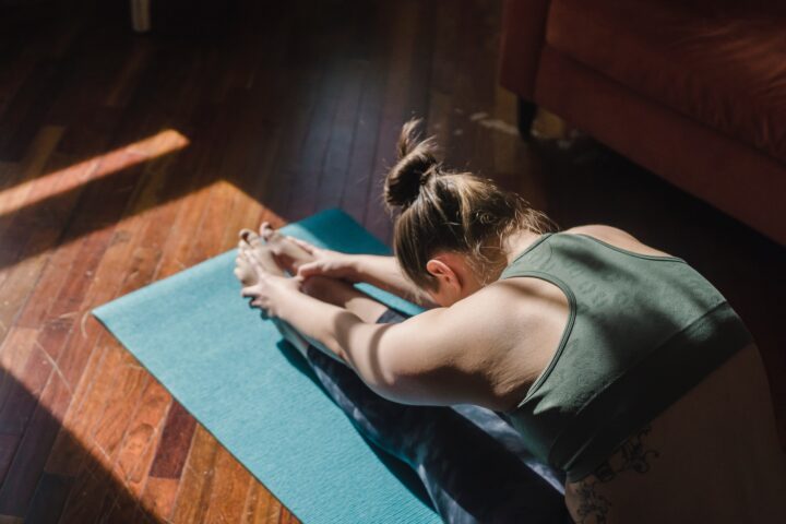 Woman stretching on exercise mat.