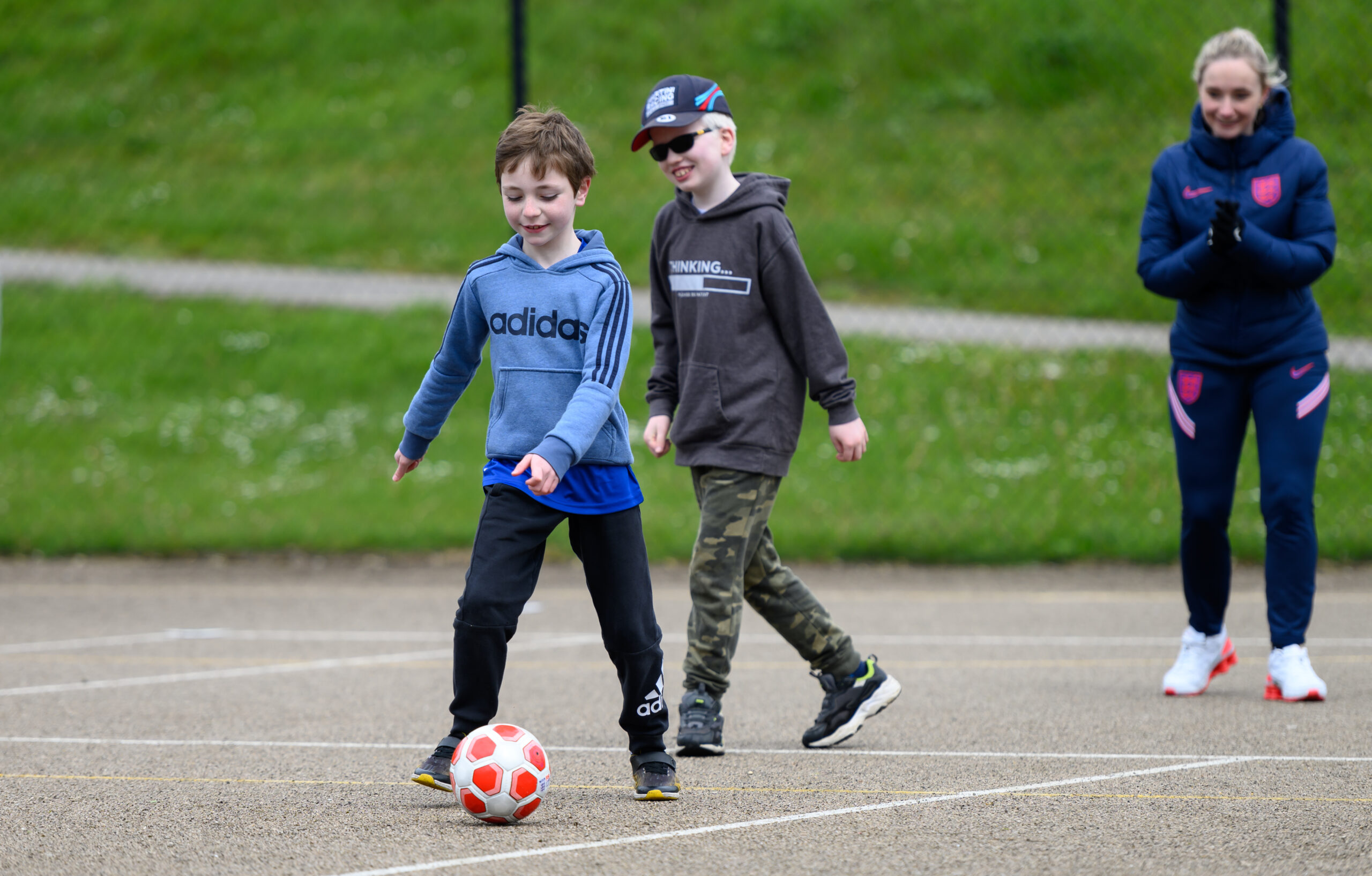 Children playing football outdoors.