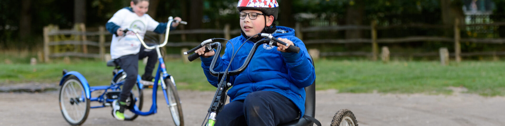 A young person with a disability cycling outdoors. (Image by Sport England.)