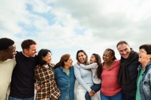 Image shows group of happy smiling multigenerational friends